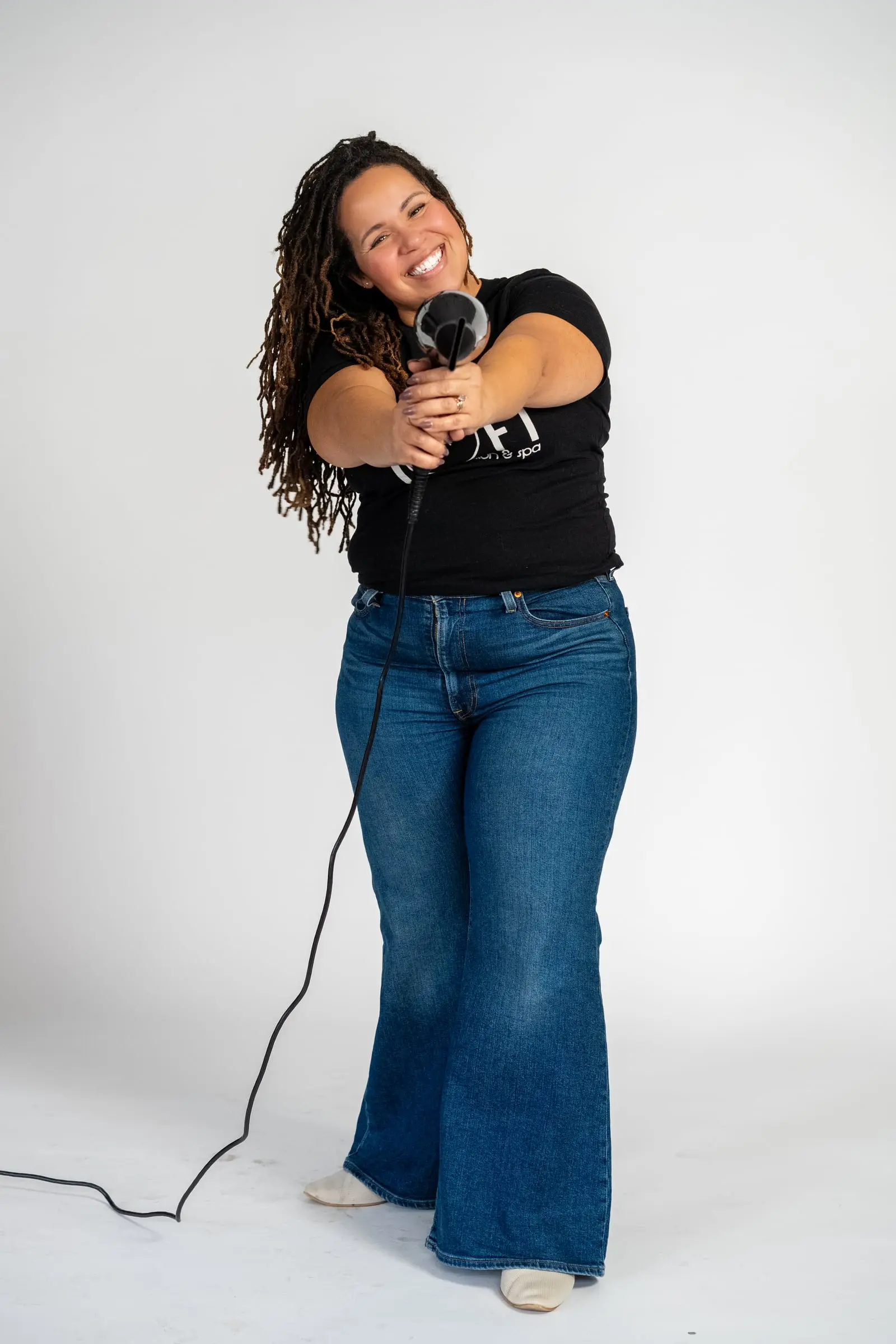 Loft stylist aiming a blow dryer at the camera