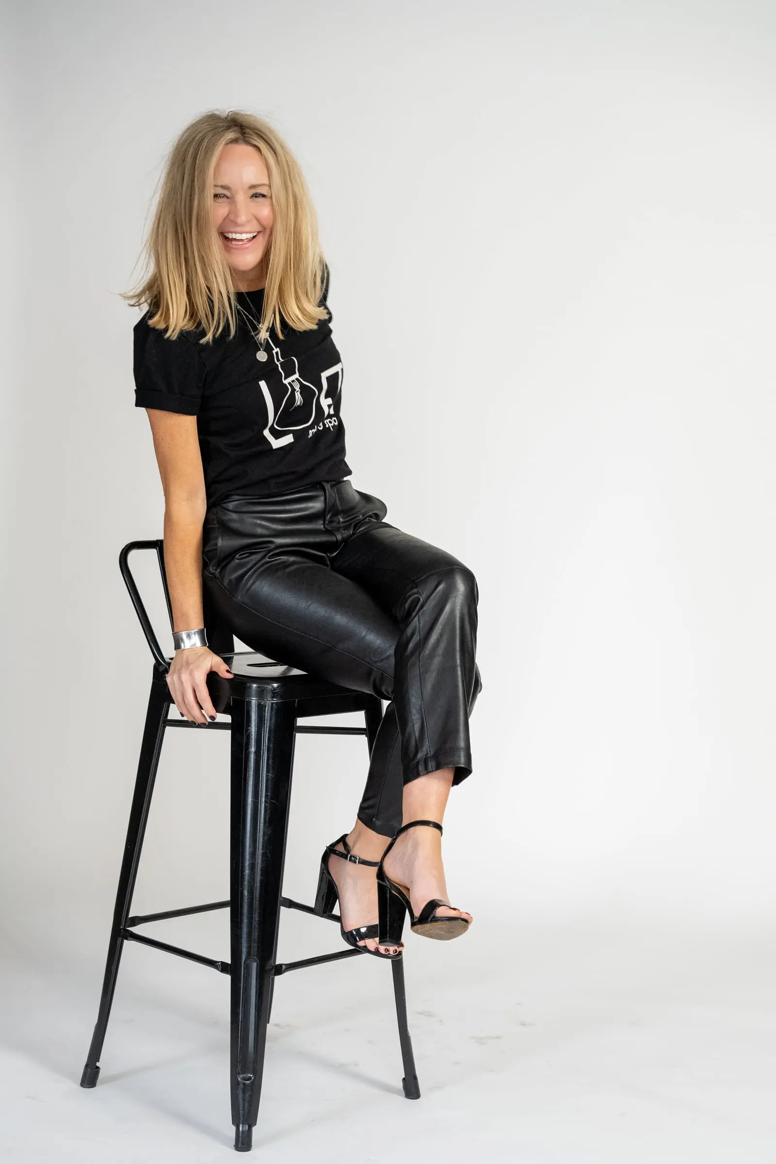 Loft stylist perched on a black bar stool